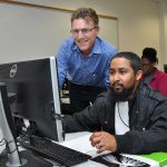 student and instructor at a computer