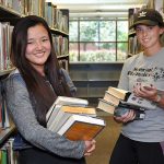 two girls holding books