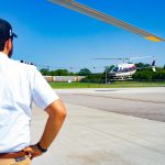 Helicopter landing with instructor watching.