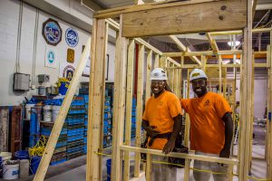 Two students posing for photographer in construction carpentry.