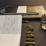 Cannabis bud lineup, stationery, jar, pages on black back