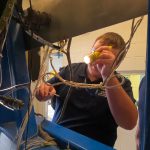 Aviation maintenance student using flashlight